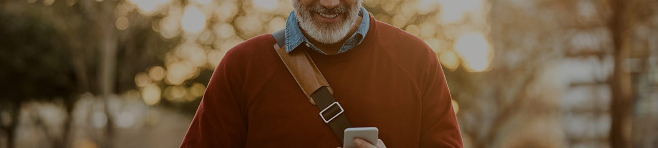 Man Walking at Sunset Looking at Mobile Phone