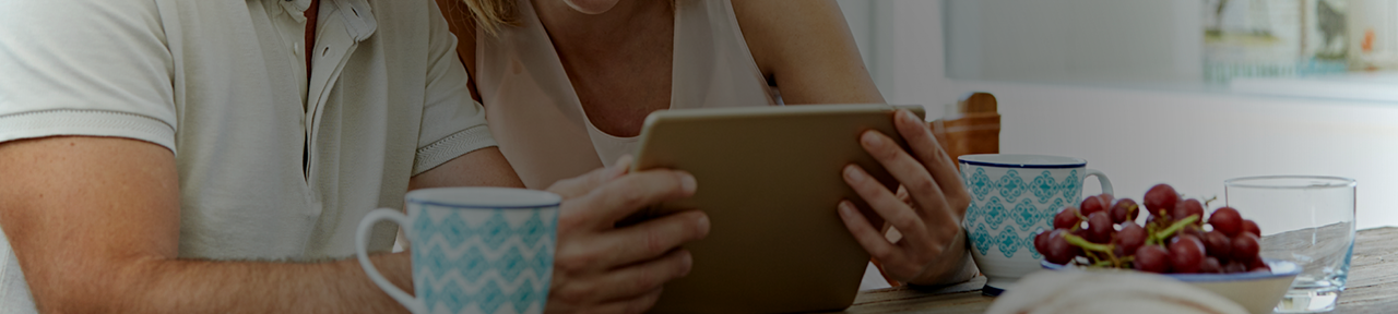 Couple Eating Breakfast and Browsing Accounts on Tablet