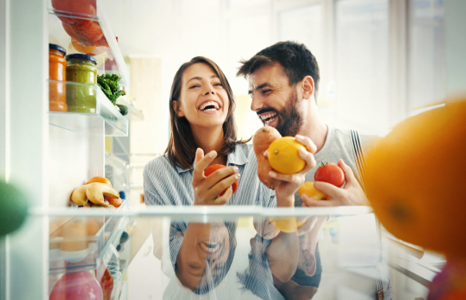 Couple Laughing While Organizing Fridge