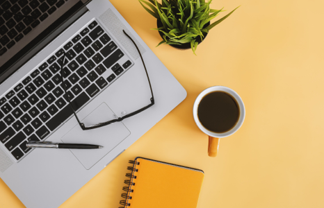 Desk with Laptop, Glasses, Coffee, Notebook and Pen