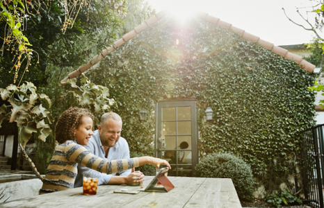 Father and Daughter Sitting in Backyard Using a Tablet