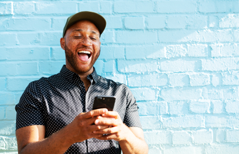 Man Smiling While Checking Personal Account Interest Rates.png