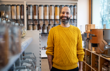 Man in Yellow Sweater Smiling in Coffee Shop