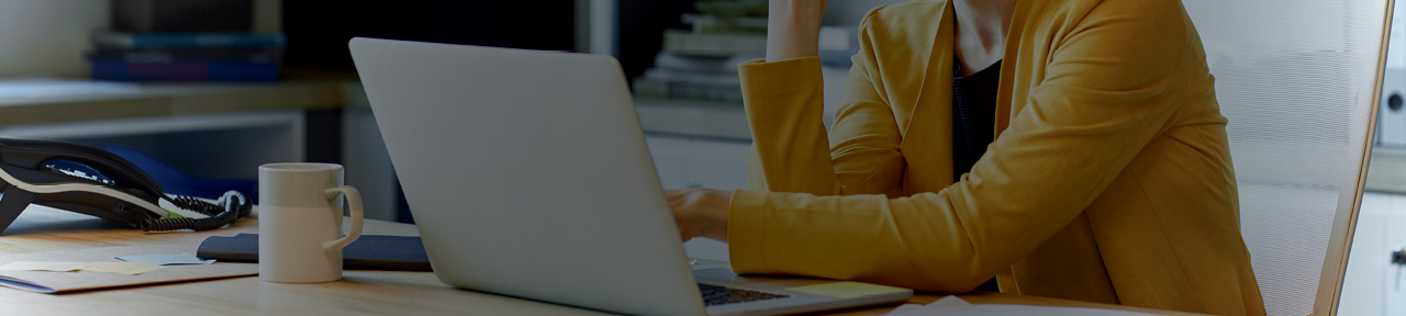 Person in Yellow Blazer Using Laptop to Contact Wealth Advisor