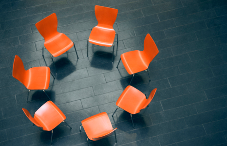 Seven Orange Chairs Arranged in a Circle