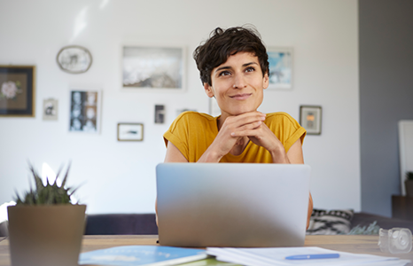 Smiling Woman Sitting in Front of Laptop
