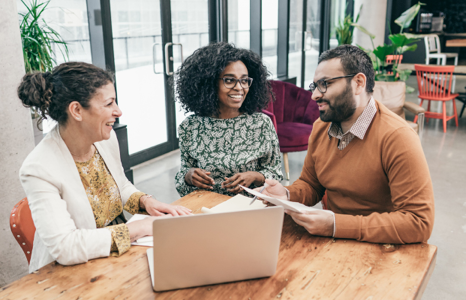 Three People Collaborating Around Laptop