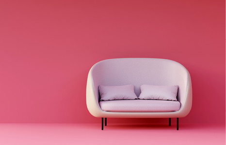 White Couch with Two Cushions in Front of Pink Wall