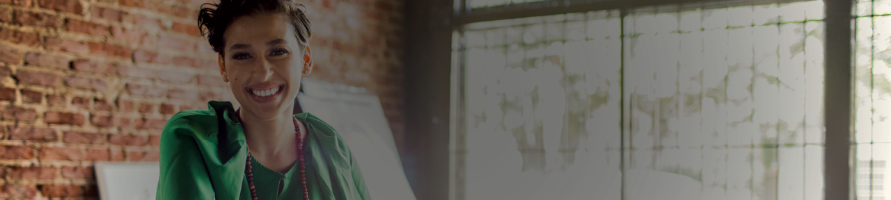 Woman in Green Shirt Smiling in Naturally Lit Room.png