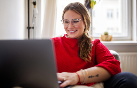 Woman in Red Sweater Using Laptop on Couch