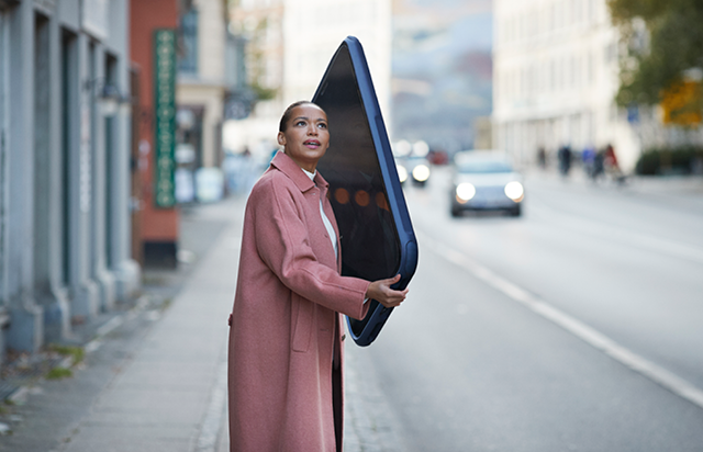 Woman in Pink Coat Holding Giant Smartphone