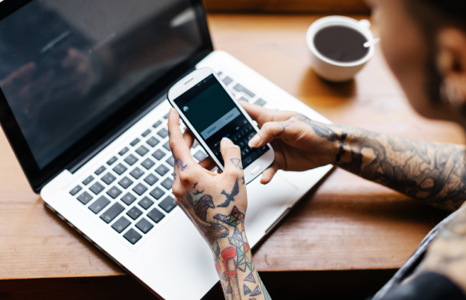 Person Using Mobile Phone and Laptop for Banking