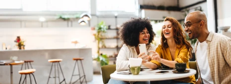 Friends sitting and laughing together at a cafe