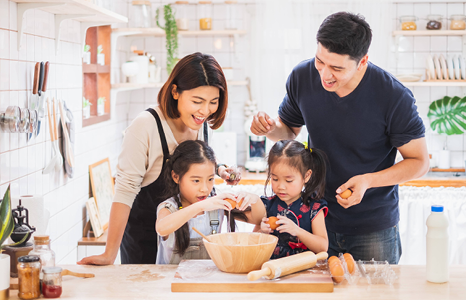 Family of Four Cooking Together in Kitchen 