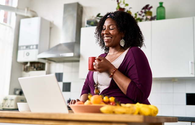 Woman Smiling While Browsing Laptop