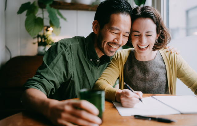 Couple Smiling While Reviewing Documents